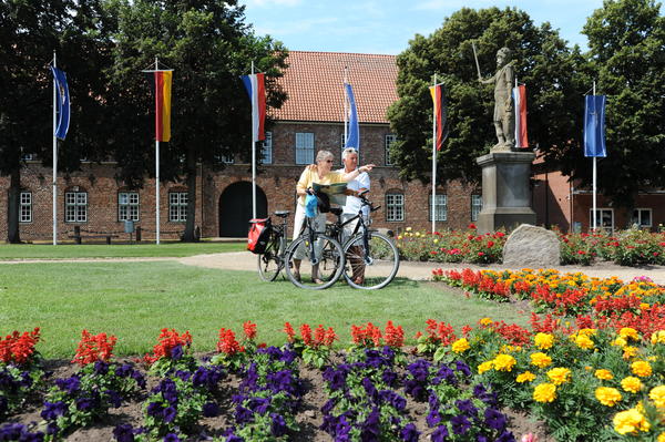 Fahrradfahrer am Roland vor dem Schloss-Torhaus