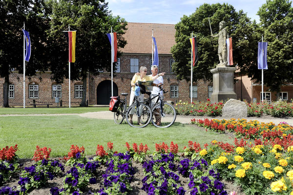 Fahrradfahrer am Roland vor dem Schloss-Torhaus